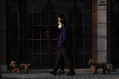 2 men are walking with pets