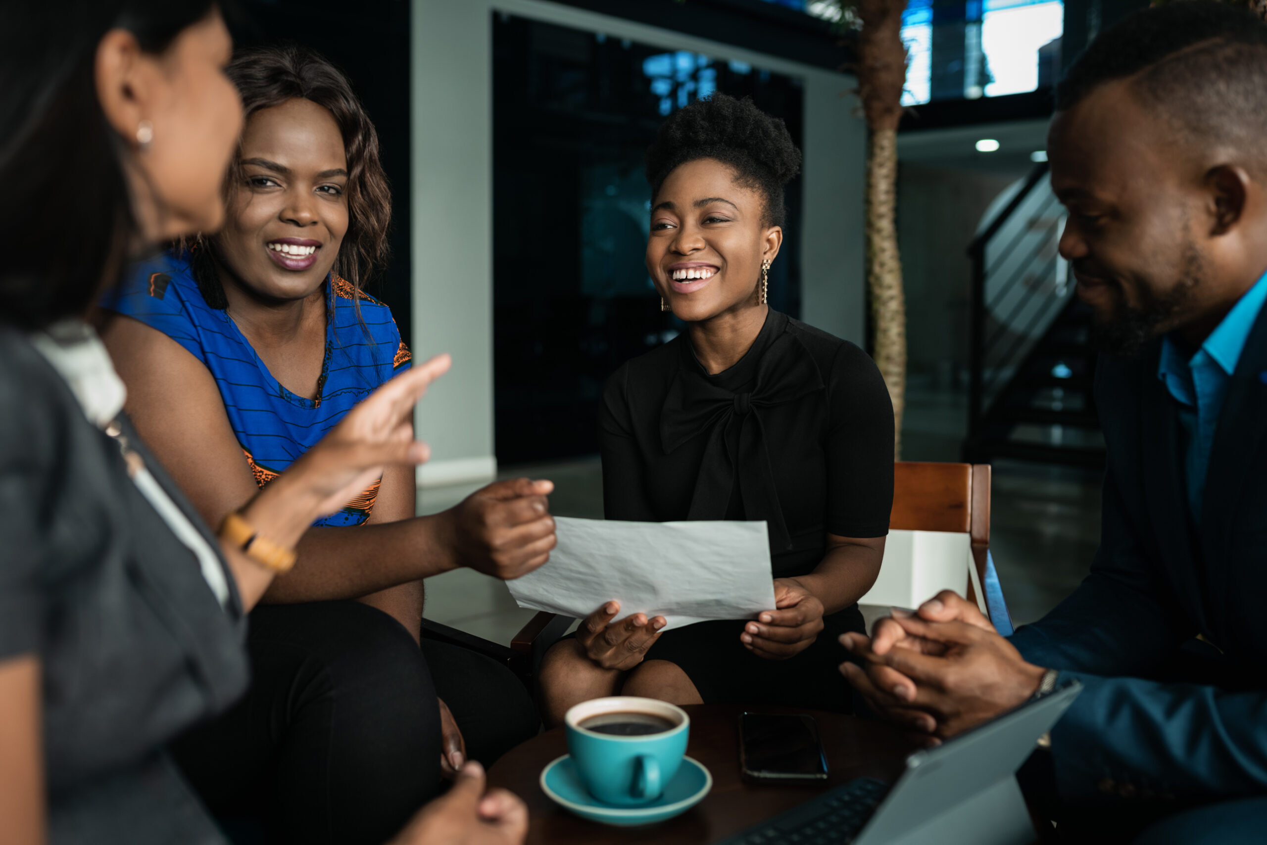 Young,African,Businesspeople,Laughing,Together,While,Going,Over,Paperwork,During